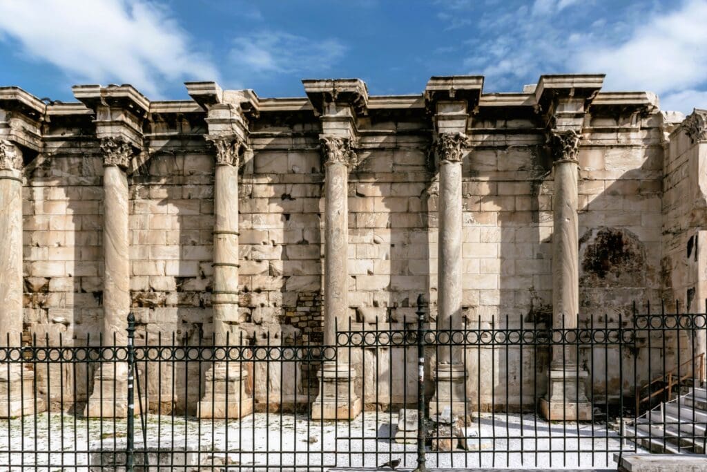 An old building with columns and a fence.