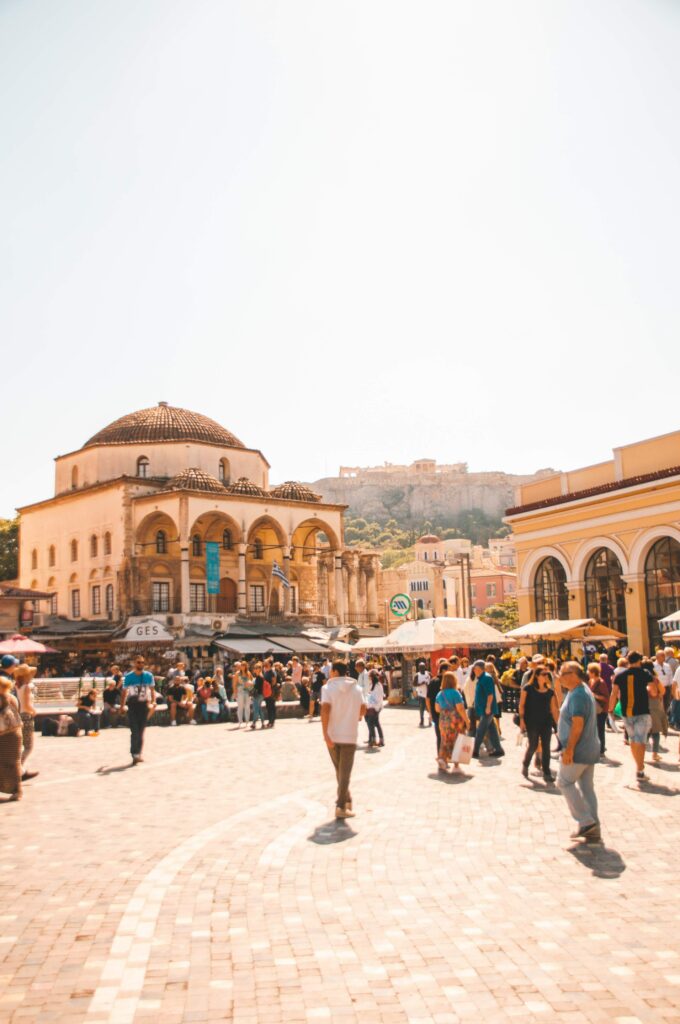 A city square with people walking around on a sunny day.