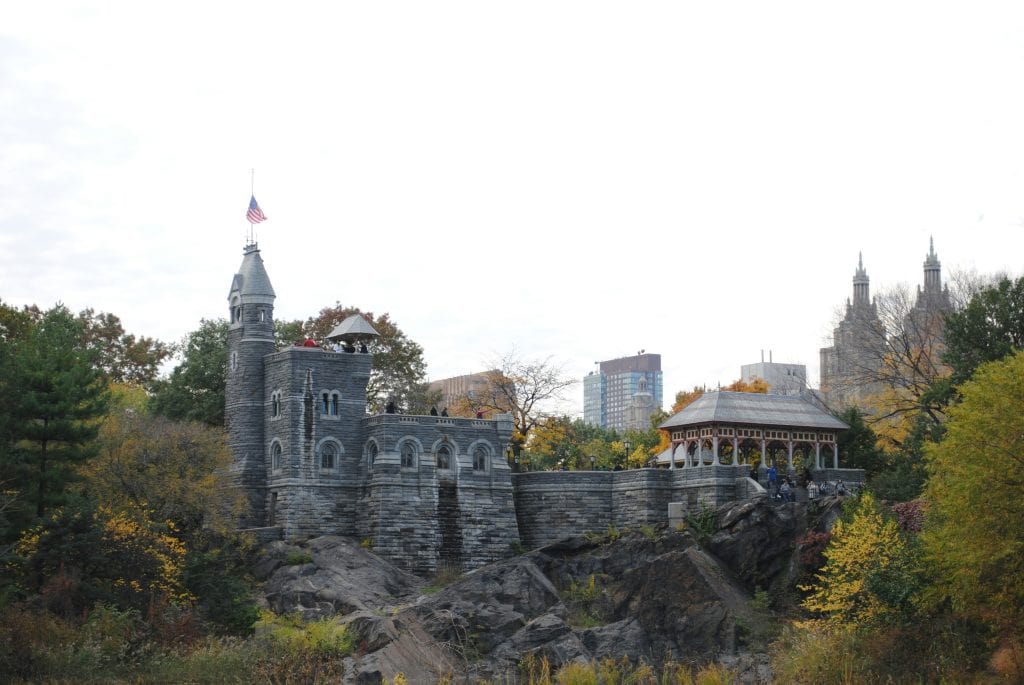 Belvedere Castle and a pavilion in Central Park, surrounded by trees with city buildings in the background—one of the best attractions in Central Park.