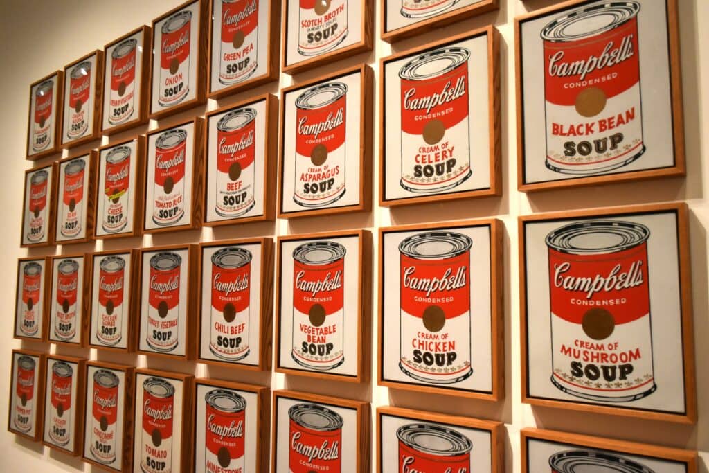 A wall of cans of soup on a wall.