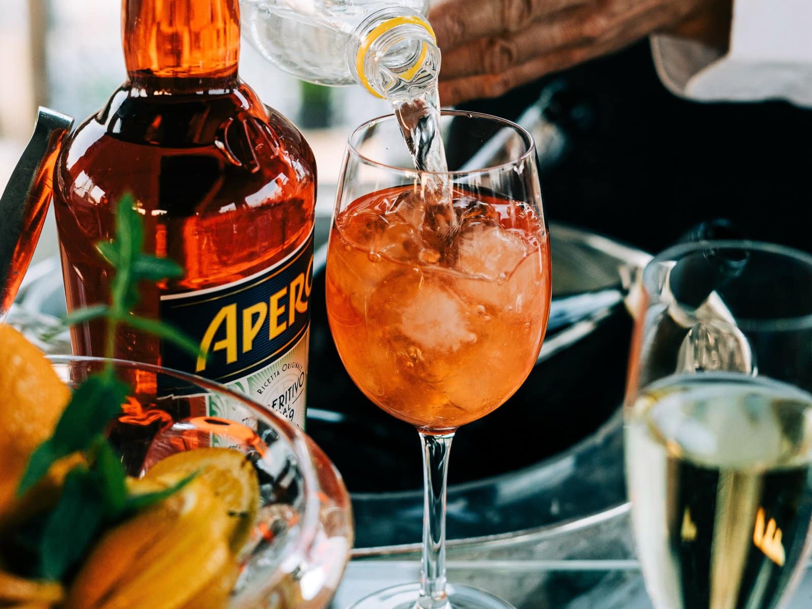 In Rome, expect the perfect Aperitivo experience as you watch a bartender skillfully pour a refreshing cocktail into a glass.