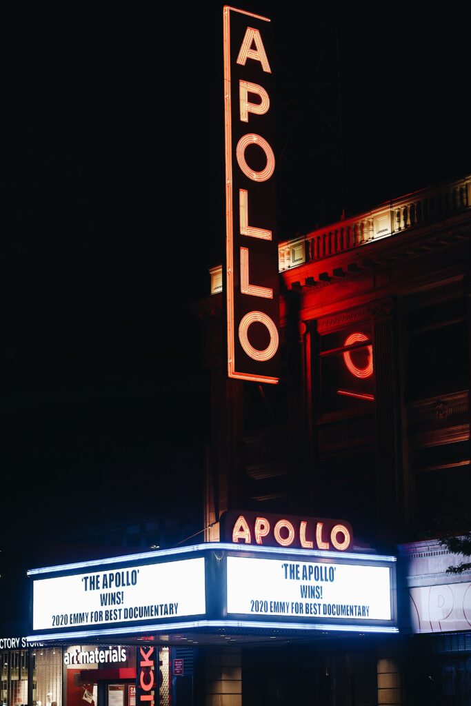 The popular Apollo Theater in Manhattan is lit up at night in the areas surrounding it.