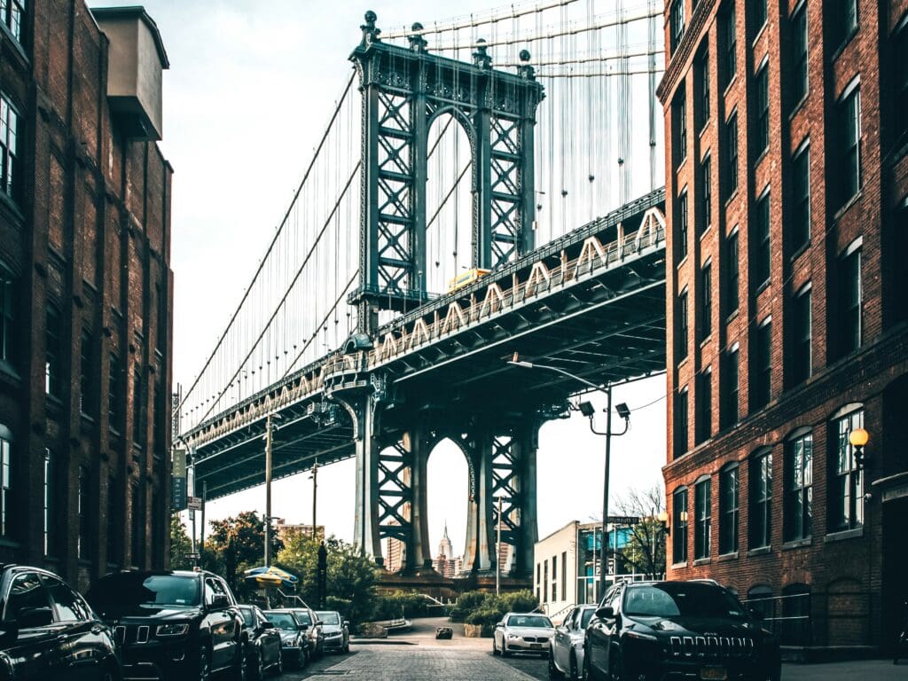 Cars parked under the Brooklyn Bridge.