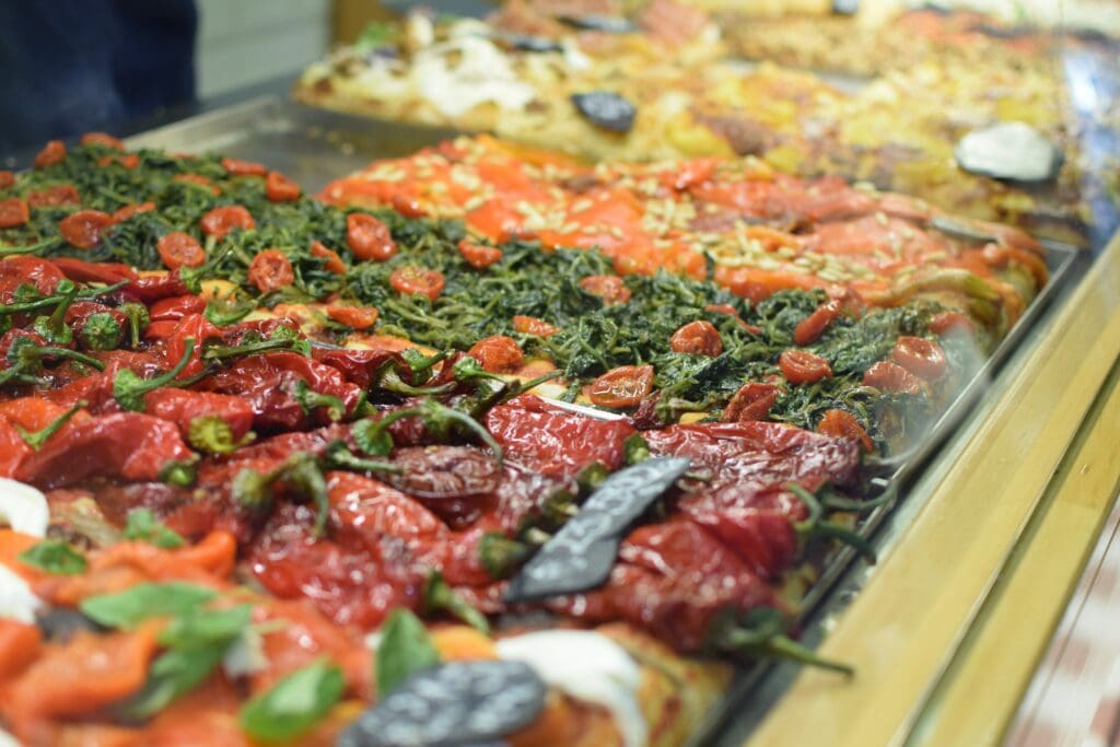 A display of Roman pizzas in a glass case.