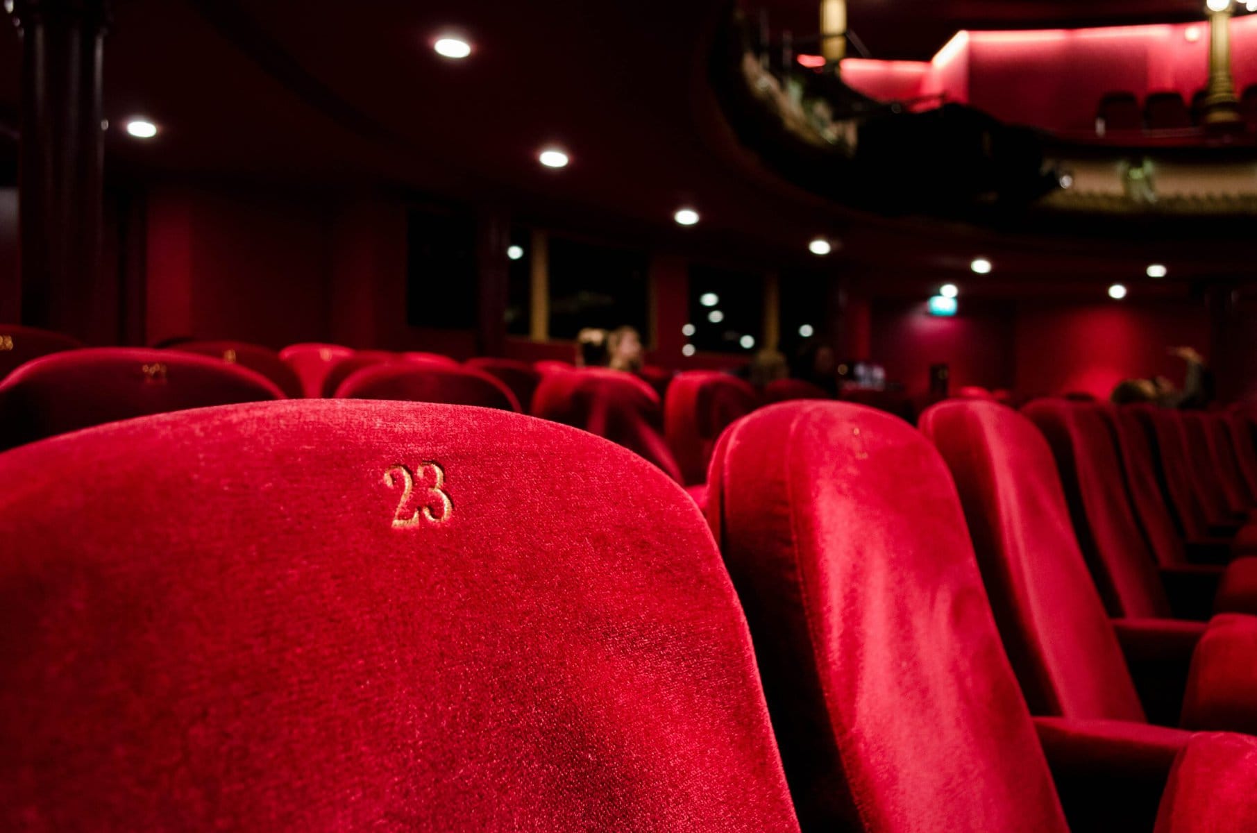 A row of red seats in a Broadway auditorium.