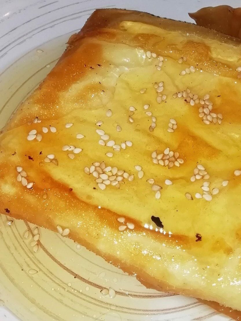 A plate with a piece of Saganaki on it.