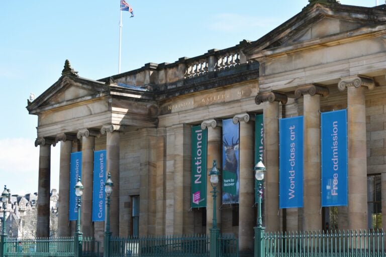 Historic building with columns draped in British flags and banners that read "National," "World-class art," and "Free admission." One of Edinburgh's must-visit museums.