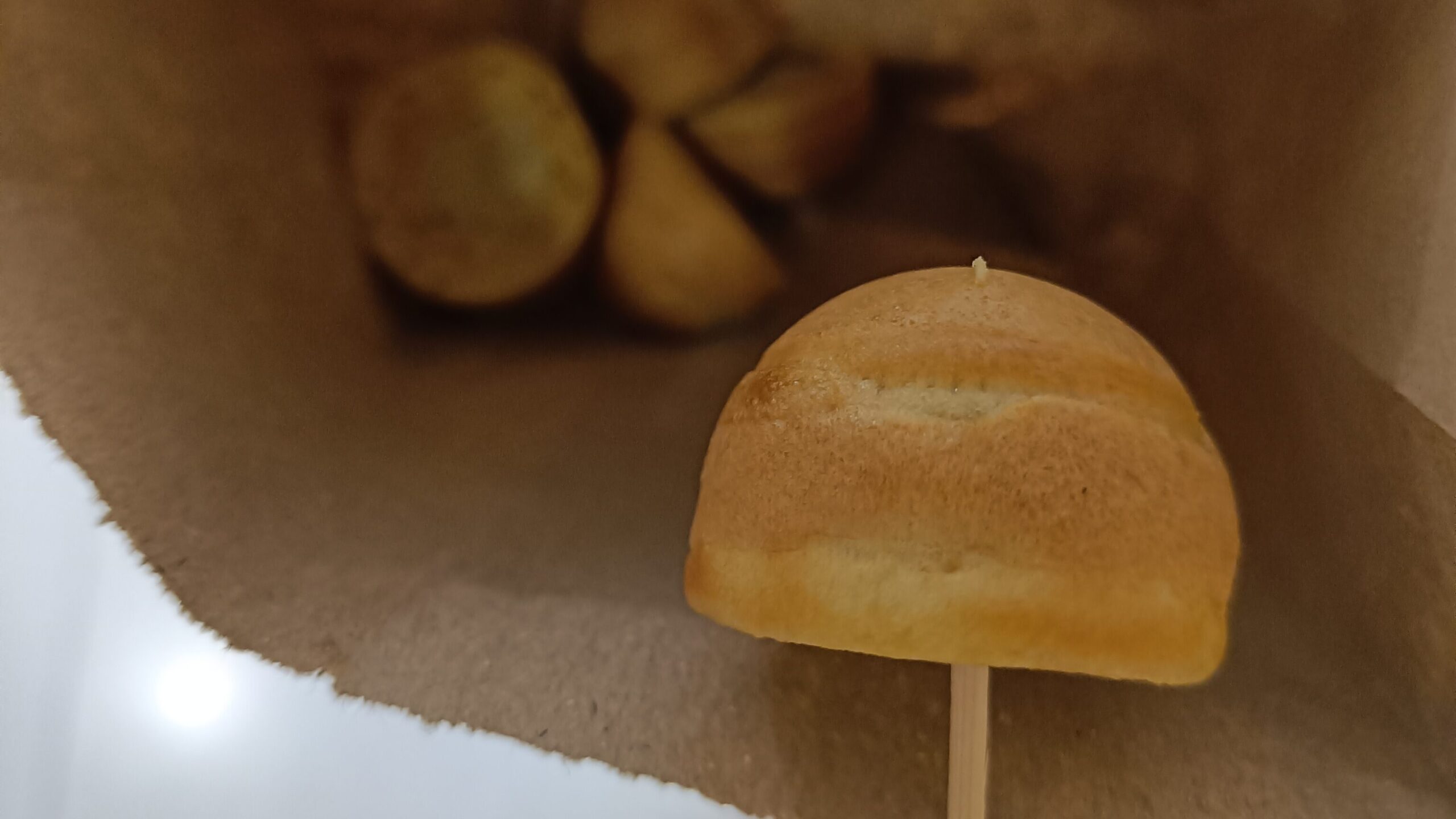 A delightful taste of Singapore, these small pastries come nestled in a brown paper bag, with one artistically presented on a skewer.