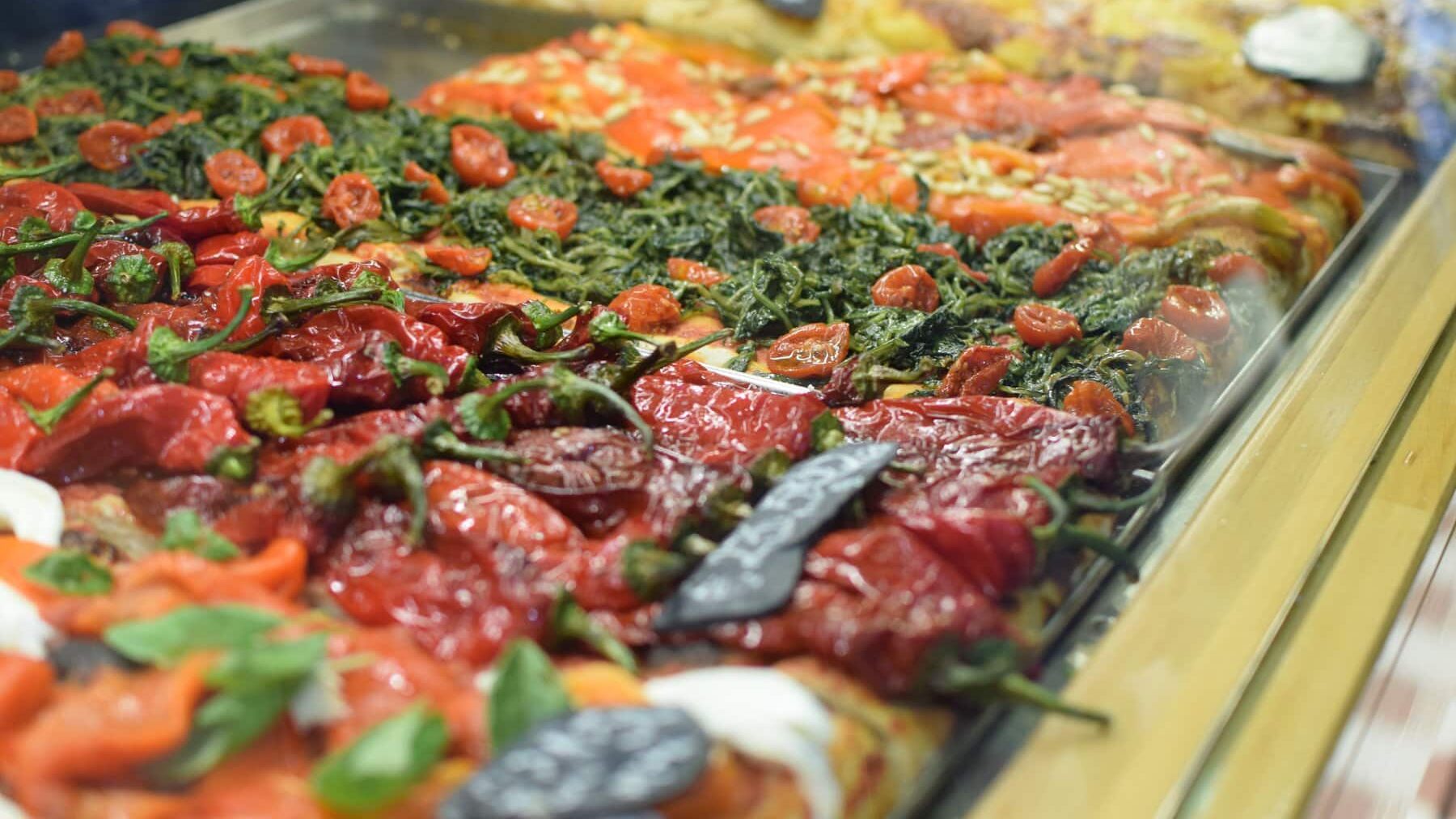 A display of Roman pizzas in a glass case.