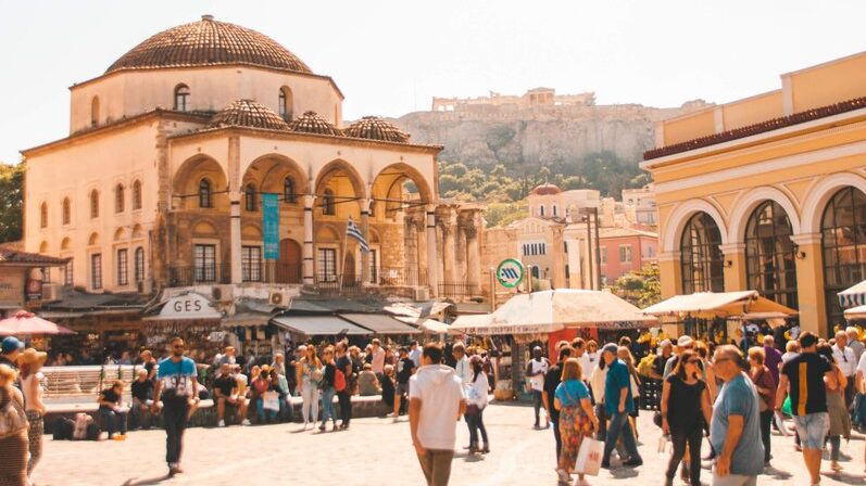 A city square with people walking around on a sunny day.