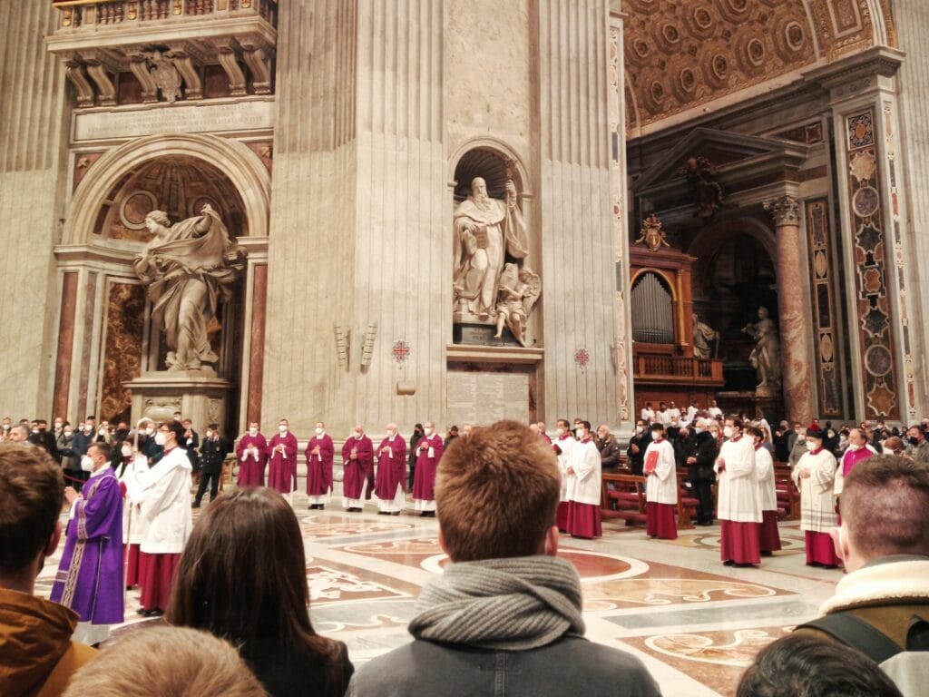 A festive religious ceremony inside Rome's grand cathedral featured clergy in robes and a congregation of people watching attentively.