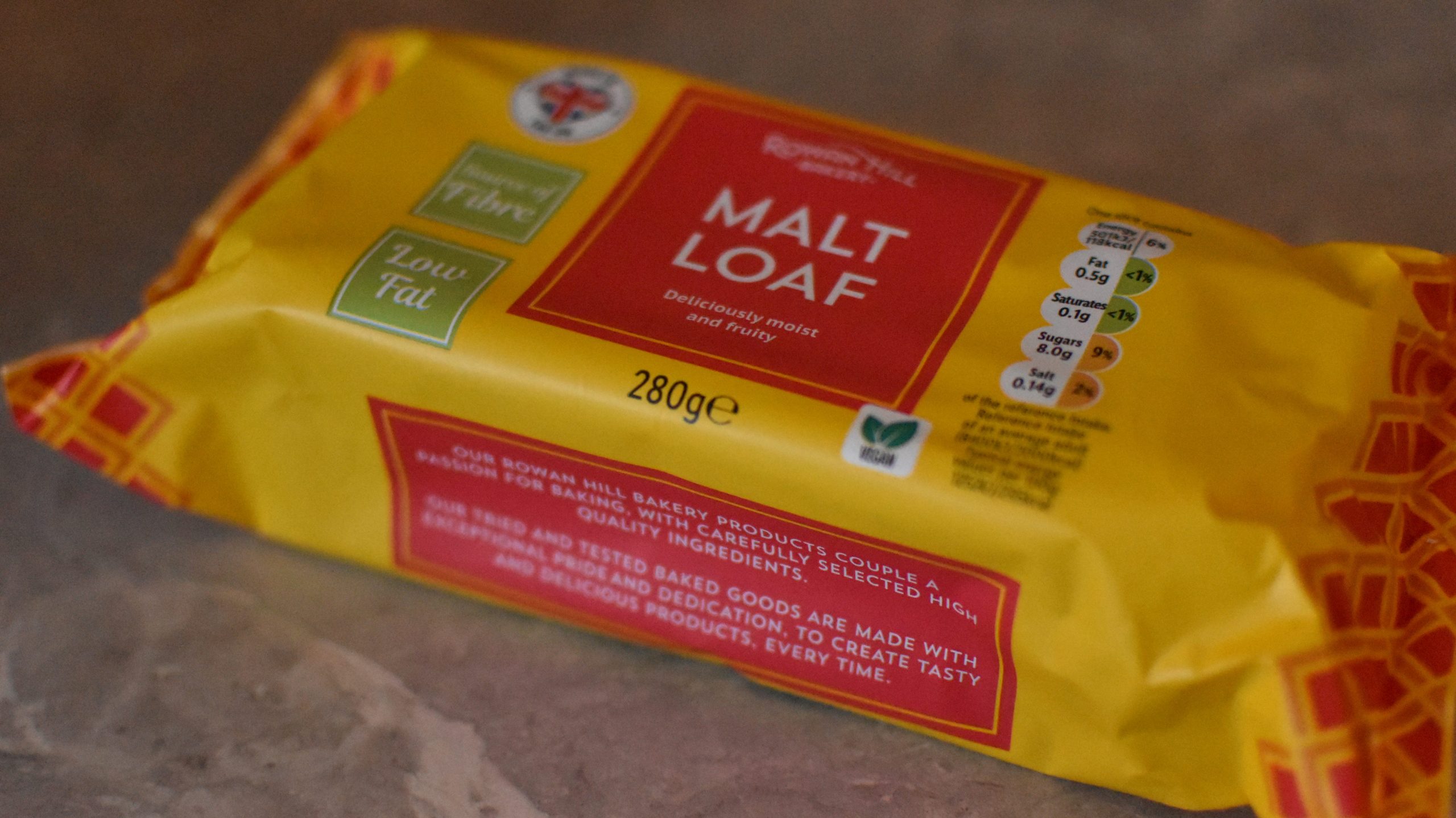 A yellow 280g pack of malt loaf with nutrition labels sits on a marble surface—perfect as one of the classic food souvenirs Glasgow visitors love to bring home.