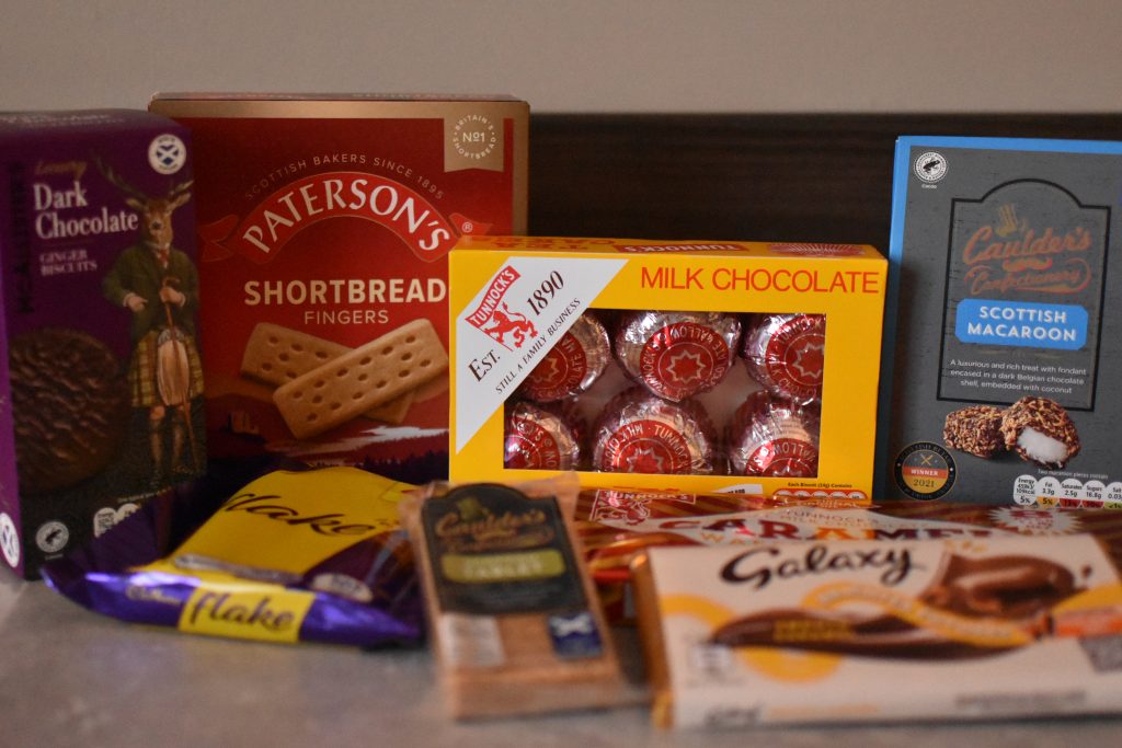 A selection of Scottish and British chocolates, biscuits, and sweets arranged on a table—perfect Glasgow food souvenirs to take home or share.