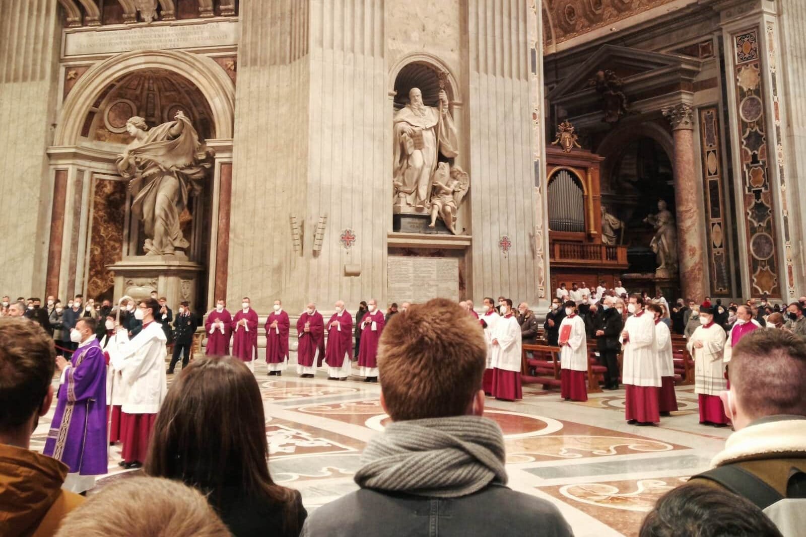 A festive religious ceremony inside Rome's grand cathedral featured clergy in robes and a congregation of people watching attentively.