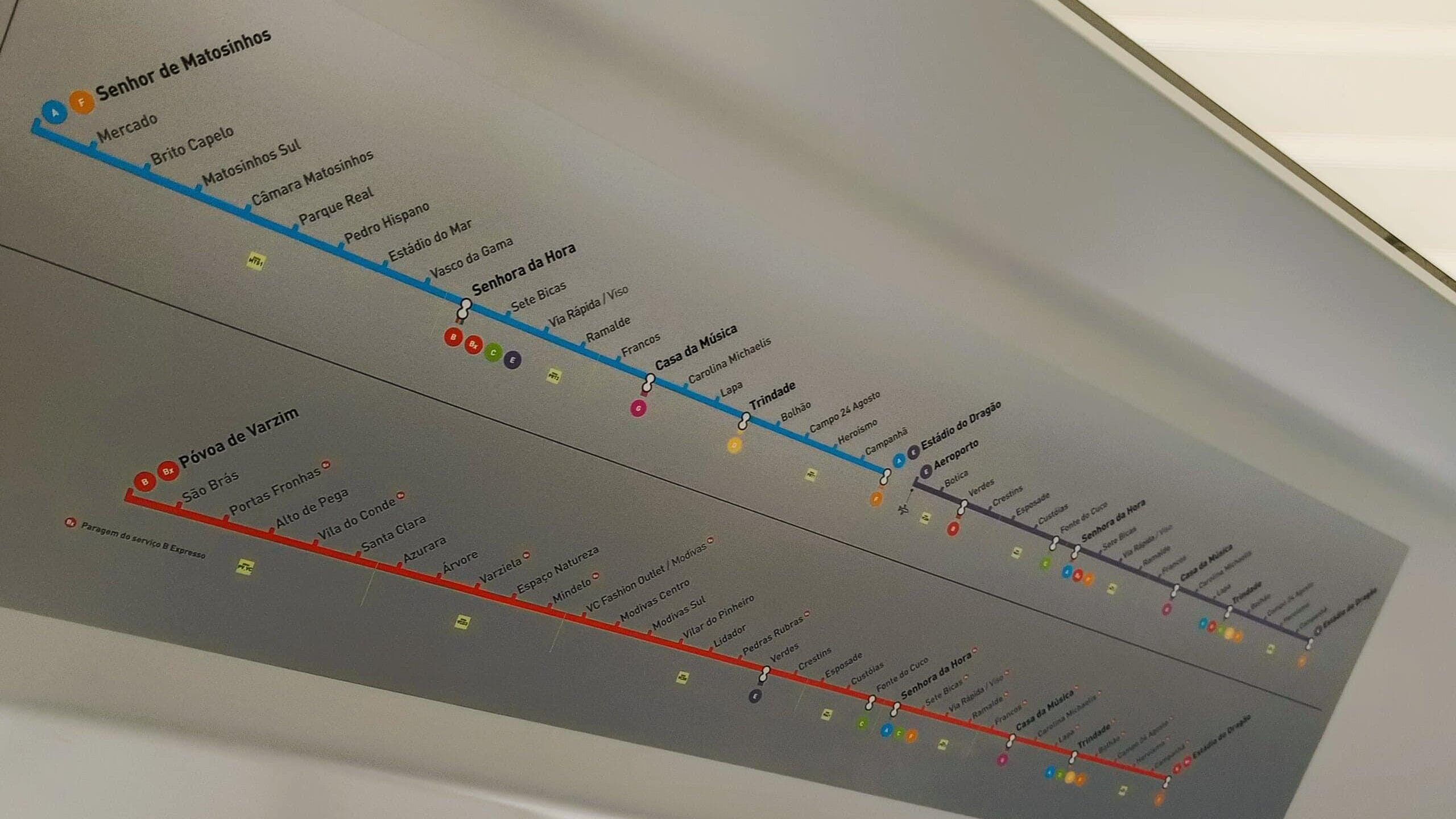 Underground map showing two coloured lines with station names listed in Portuguese on a ceiling panel, perfect for getting around Porto.