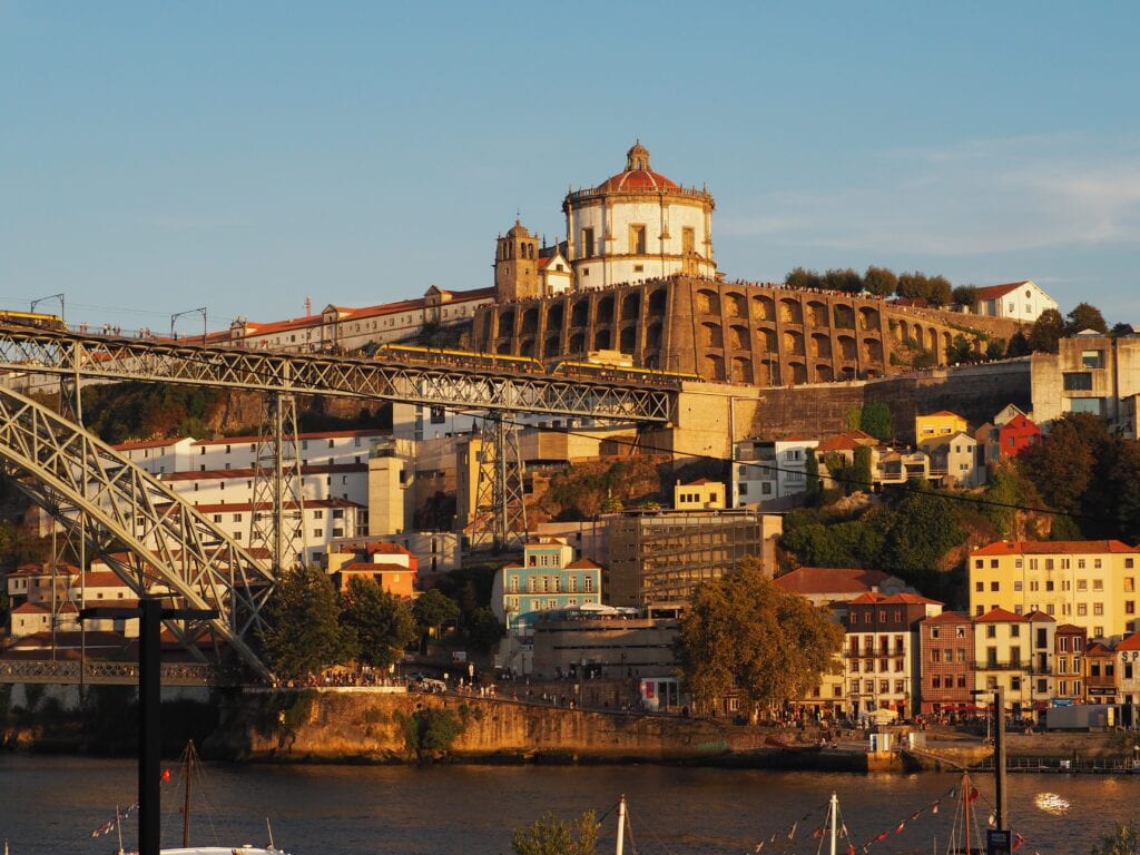Experience a stunning sunset view of the Dom Luís I Bridge and Monastery of Serra do Pilar over the Douro River in Porto—an essential highlight from any insider’s guide to the best things to do in this vibrant Portuguese city.