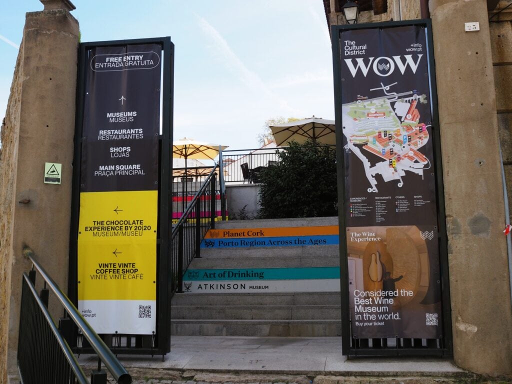 Entrance to the World of Wine Porto museum complex, with banners advertising museums, restaurants, and exhibitions on either side.